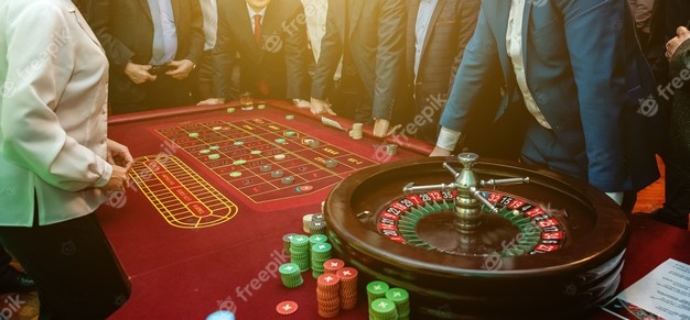 Folk står rundt et roulettebord