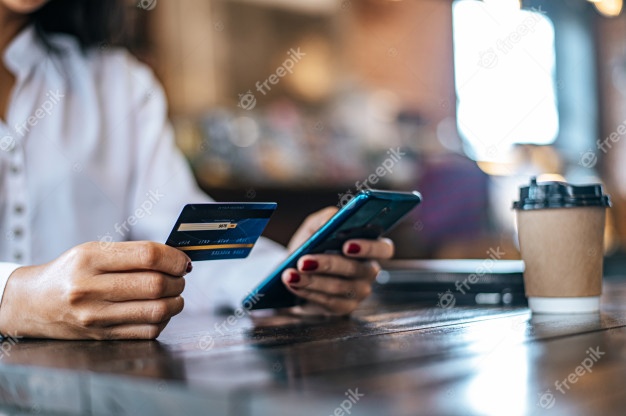 Kvinne holder bankkort og telefon